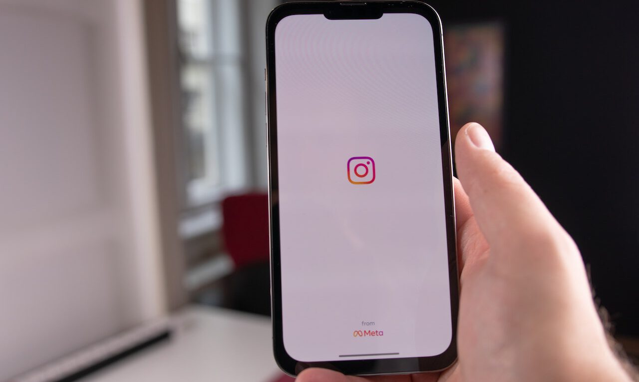 Instagram'ın özgün ve tanınmış logosunun, çeşitli renk tonlarıyla zenginleştirilmiş bir arka plan üzerinde belirgin bir şekilde öne çıktığı, detayların dikkatlice işlendiği bir fotoğraf