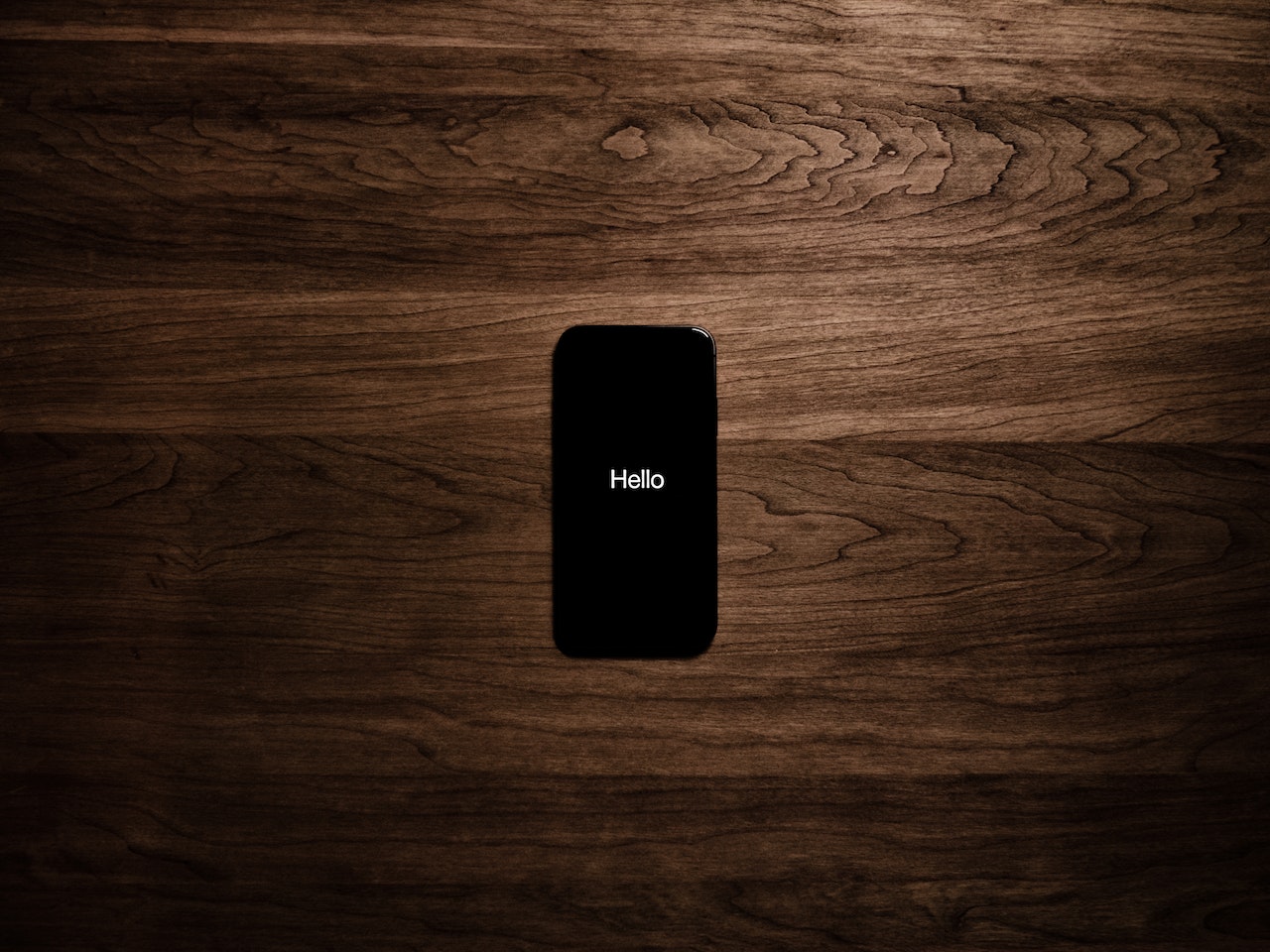 Son model bir iPhone'un yakın çekim görüntüsü. Telefonun ekranında iOS'a özgü uygulama ikonları ve ana menüsü dikkat çekiyor